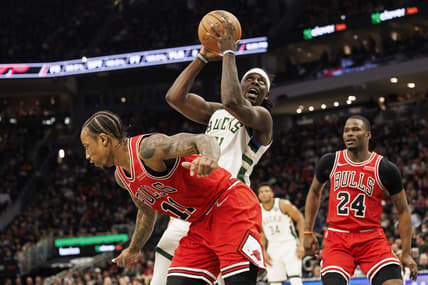 Mar 22, 2022; Milwaukee, Wisconsin, USA;  Milwaukee Bucks guard Jrue Holiday (21) shoots over Chicago Bulls guard DeMar DeRozan (11) during the third quarter at Fiserv Forum. Mandatory Credit: Jeff Hanisch-USA TODAY Sports