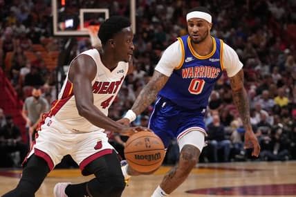 Mar 23, 2022; Miami, Florida, USA; Miami Heat guard Victor Oladipo (4) dribbles the ball around Golden State Warriors guard Gary Payton II (0) during the first half at FTX Arena. Mandatory Credit: Jasen Vinlove-USA TODAY Sports