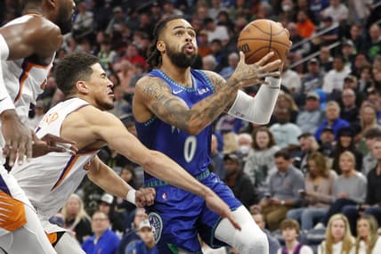 Mar 23, 2022; Minneapolis, Minnesota, USA; Minnesota Timberwolves guard D'Angelo Russell (0) moves past Phoenix Suns guard Devin Booker (1) to the basket in the first quarter at Target Center. Mandatory Credit: Bruce Kluckhohn-USA TODAY Sports