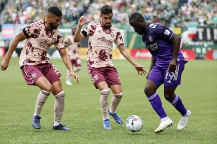 Mar 27, 2022; Portland, Oregon, USA;  Orlando City SC forward Benji Michel (19) controls the ball against Portland Timbers defender Jose Van Rankin (2) during the first half at Providence Park. Mandatory Credit: Soobum Im-USA TODAY Sports