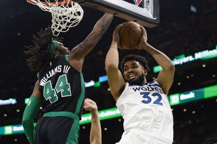 Mar 27, 2022; Boston, Massachusetts, USA; Minnesota Timberwolves center Karl-Anthony Towns (32) looks for a way around Boston Celtics center Robert Williams III (44) during the first quarter at TD Garden. Mandatory Credit: Winslow Townson-USA TODAY Sports