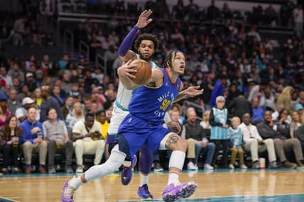 Mar 28, 2022; Charlotte, North Carolina, USA; Denver Nuggets forward Aaron Gordon (50) drives to the basket defended by Charlotte Hornets forward Miles Bridges (0) during the first quarter at Spectrum Center. Mandatory Credit: Jim Dedmon-USA TODAY Sports