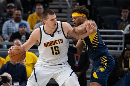 Mar 30, 2022; Indianapolis, Indiana, USA; Denver Nuggets center Nikola Jokic (15) dribbles the ball while Indiana Pacers forward Justin Anderson (10) defends in the second half at Gainbridge Fieldhouse. Mandatory Credit: Trevor Ruszkowski-USA TODAY Sports