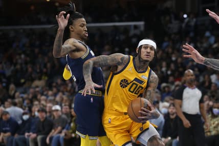 Jan 28, 2022; Memphis, Tennessee, USA; Utah Jazz guard Jordan Clarkson (00) drives to the basket as Memphis Grizzles guard Ja Morant (12) defends during the second half at FedExForum. Mandatory Credit: Petre Thomas-USA TODAY Sports
