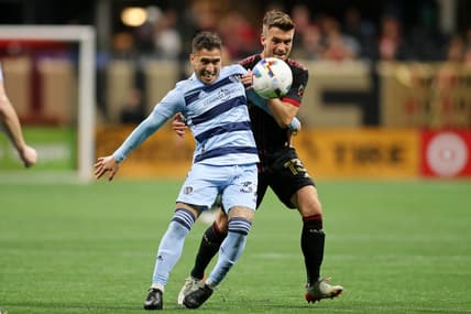 Feb 27, 2022; Atlanta, Georgia, USA; Atlanta United midfielder Amar Sejdic (13) battles for the ball against Sporting Kansas City midfielder Jose Mauri (32) during the second half at Mercedes-Benz Stadium. Atlanta United won 3-1. Mandatory Credit: Brett Davis-USA TODAY Sports