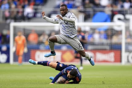 Apr 2, 2022; Cincinnati, Ohio, USA;  CF Montreal defender Zachary Brault-Guillard (15) leaps over FC Cincinnati midfielder Luciano Acosta (10) in the second half at TQL Stadium. Mandatory Credit: Aaron Doster-USA TODAY Sports