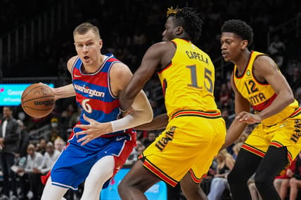 Apr 6, 2022; Atlanta, Georgia, USA; Washington Wizards center Kristaps Porzingis (6) dribbles against Atlanta Hawks center Clint Capela (15) and forward De'Andre Hunter (12) during the first half at State Farm Arena. Mandatory Credit: Dale Zanine-USA TODAY Sports