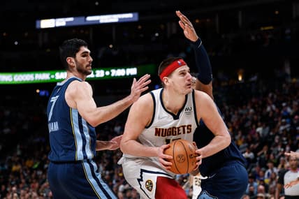 Apr 7, 2022; Denver, Colorado, USA; Denver Nuggets center Nikola Jokic (15) controls the ball as Memphis Grizzlies center Xavier Tillman Sr. (2) and forward Santi Aldama (7) guards in the fourth quarter at Ball Arena. Mandatory Credit: Isaiah J. Downing-USA TODAY Sports