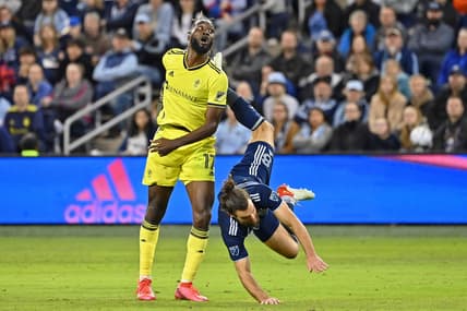 Apr 9, 2022; Kansas City, Kansas, USA; Sporting Kansas City defender Graham Zusi (8) is upended after making a play for the ball against Nashville SC forward C.J. Sapong (17) during the first half at Children's Mercy Park. Mandatory Credit: Peter Aiken-USA TODAY Sports
