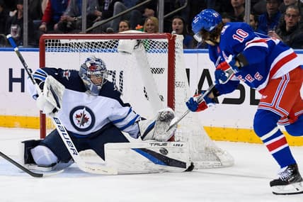Apr 19, 2022; New York, New York, USA;  Winnipeg Jets goaltender Eric Comrie (1) makes a save on a shot from New York Rangers left wing Artemi Panarin (10) during the first period at Madison Square Garden. Mandatory Credit: Dennis Schneidler-USA TODAY Sports