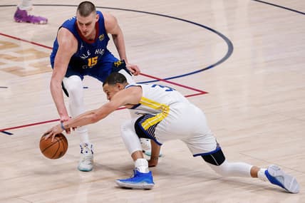 Apr 21, 2022; Denver, Colorado, USA; Golden State Warriors guard Stephen Curry (30) and Denver Nuggets center Nikola Jokic (15) battle for a loose ball in the fourth quarter during game three of the first round of the 2022 NBA playoffs at Ball Arena. Mandatory Credit: Isaiah J. Downing-USA TODAY Sports