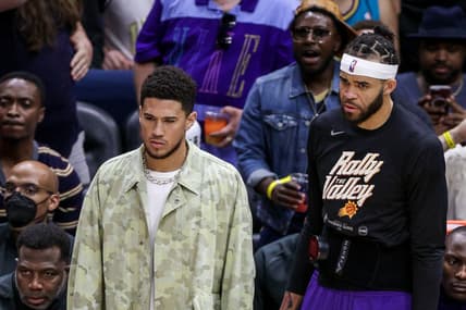 Apr 24, 2022; New Orleans, Louisiana, USA;  Phoenix Suns guard Devin Booker (1) and center JaVale McGee (00) look on from the bench against the New Orleans Pelicans during the first half of game four of the first round for the 2022 NBA playoffs at Smoothie King Center. Mandatory Credit: Stephen Lew-USA TODAY Sports