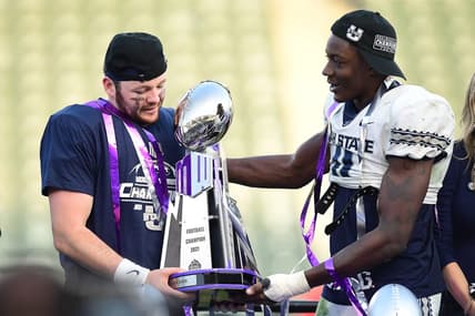 Dec 4, 2021; Carson, CA, USA; Utah State Aggies quarterback Logan Bonner (1) and defensive end Byron Vaughns (11) hold the champions trophy following the victory against the San Diego State Aztecs in the Mountain West Conference championship game at Dignity Health Sports Park. Mandatory Credit: Gary A. Vasquez-USA TODAY Sports