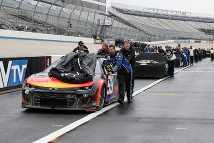 May 1, 2022; Dover, Delaware, USA; NASCAR Cup Series teams push their cars to the garage after the DuraMAX Drydene 400 has been postponed due to weather at Dover Motor Speedway. Mandatory Credit: Matthew OHaren-USA TODAY Sports