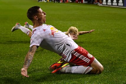 Apr 30, 2022; Chicago, Illinois, USA;  New York Red Bulls forward Patryk Klimala (9), left, and New York Red Bulls defender John Tolkin (47) slide on the field after Klimala scored a goal during the second half against the Chicago Fire at Soldier Field. Mandatory Credit: Matt Marton-USA TODAY Sports