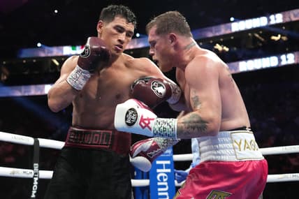 May 7, 2022; Las Vegas, Nevada, USA; Canelo Alvarez (pink trunks) and Dmitry Bivol (black trunks) box during their light heavyweight championship bout at T-Mobile Arena. Mandatory Credit: Joe Camporeale-USA TODAY Sports