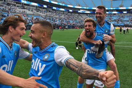 May 7, 2022; Charlotte, North Carolina, USA; Charlotte FC attacker Andre Shinyashiki (16) celebrates with midfielder Benjamin Bender (15) and defender Guzman Corujo (4) and defender Christian Fuchs (22) after the match at Bank of America Stadium. Mandatory Credit: Bob Donnan-USA TODAY Sports