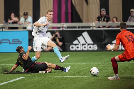 May 15, 2022; Atlanta, Georgia, USA; New England Revolution forward Adam Buksa (9) scores a goal past Atlanta United defender Alex De John (3) and goalkeeper Bobby Shuttleworth (18) during the first half at Mercedes-Benz Stadium. Mandatory Credit: Dale Zanine-USA TODAY Sports