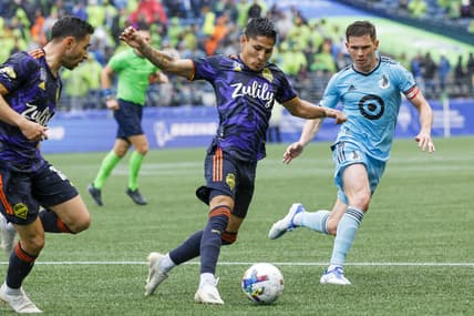 May 15, 2022; Seattle, Washington, USA; Seattle Sounders FC forward Raul Ruidiaz (9) dribbles against Minnesota United FC midfielder Will Trapp (20) during the first half at Lumen Field. Mandatory Credit: Joe Nicholson-USA TODAY Sports