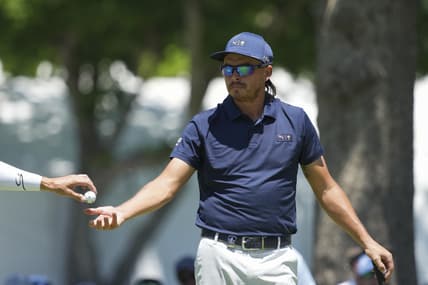May 16, 2022; Tulsa, Oklahoma, USA; Rickie Fowler gets his ball from his caddie on the 3rd green during a practice round for the PGA Championship golf tournament at Southern Hills Country Club. Mandatory Credit: Michael Madrid-USA TODAY Sports