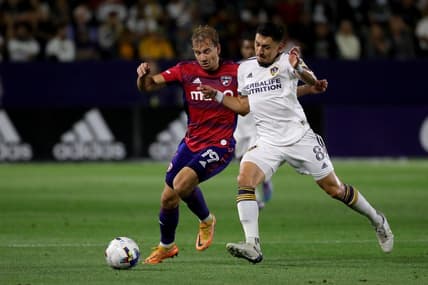May 14, 2022; Carson, California, USA;  FC Dallas midfielder Paxton Pomykal (19) and Los Angeles Galaxy midfielder Marco Delgado (8) battles for the ball during the second half at Dignity Health Sports Park. Mandatory Credit: Kiyoshi Mio-USA TODAY Sports