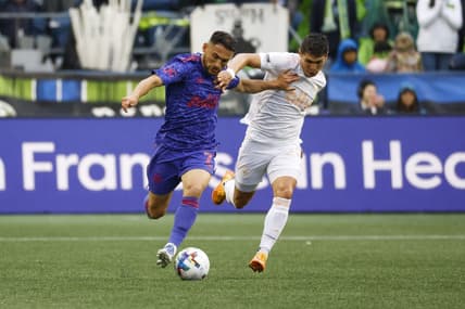 May 29, 2022; Seattle, Washington, USA; Seattle Sounders FC midfielder Cristian Roldan (7) and Charlotte FC defender Joseph Mora (28) pursue an outlet pass during the first half at Lumen Field. Mandatory Credit: Joe Nicholson-USA TODAY Sports