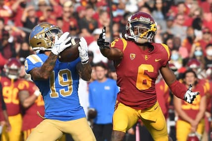 Nov 20, 2021; Los Angeles, California, USA;  UCLA Bruins running back Kazmeir Allen (19) catches a touchdown pass against Southern California Trojans cornerback Isaac Taylor-Stuart (6) in the first half at the Los Angeles Memorial Coliseum. Mandatory Credit: Richard Mackson-USA TODAY Sports