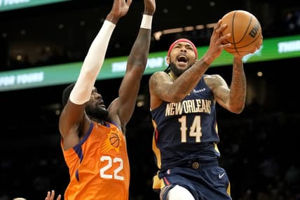 Feb 25, 2022; Phoenix, Arizona, USA; New Orleans Pelicans forward Brandon Ingram (14) drives past Phoenix Suns center Deandre Ayton (22) in the first half at Footprint Center. Mandatory Credit: Rick Scuteri-USA TODAY Sports