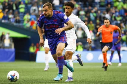 May 29, 2022; Seattle, Washington, USA; Seattle Sounders FC forward Jordan Morris (13) dribbles ahead of Charlotte FC defender Christian Makoun (14) during the first half at Lumen Field. Mandatory Credit: Joe Nicholson-USA TODAY Sports