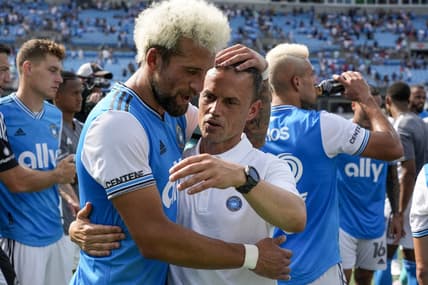 Jun 11, 2022; Charlotte, North Carolina, USA; Interim Charlotte FC head coach Christian Lattanzio and defender Guzm n Corujo (4) celebrate the home win over the New York Red Bulls at Bank of America Stadium. Mandatory Credit: Jim Dedmon-USA TODAY Sports