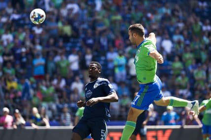 Jun 25, 2022; Seattle, Washington, USA; Seattle Sounders FC forward Will Bruin (17) scores a goal on a header against Sporting Kansas City defender Nicolas Isimat-Mirin (5) during the first half at Lumen Field. Mandatory Credit: Joe Nicholson-USA TODAY Sports