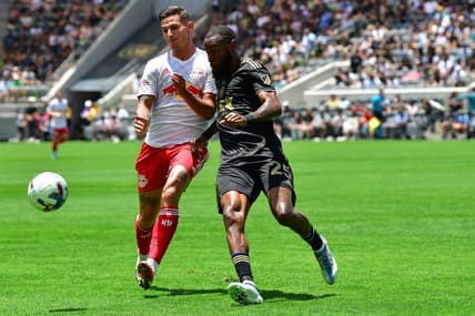 Jun 26, 2022; Los Angeles, California, USA; Los Angeles FC defender Sebastien Ibeagha (25) plays for the ball against New York Red Bulls forward Patryk Klimala (9) during the first half at Banc of California Stadium. Mandatory Credit: Gary A. Vasquez-USA TODAY Sports