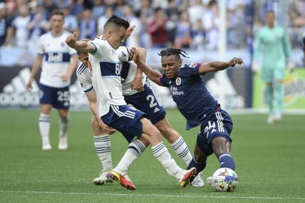 Jun 26, 2022; Vancouver, British Columbia, CAN;  New England Revolution forward DeJuan Jones (24) reaches for the ball against Vancouver Whitecaps defender Marcus Godinho (2) during the first half at BC Place. Mandatory Credit: Anne-Marie Sorvin-USA TODAY Sports