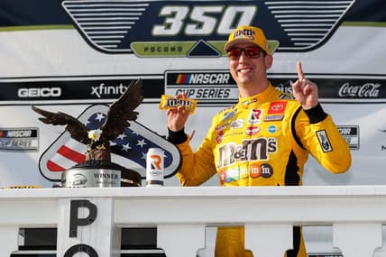 Jun 27, 2021; Long Pond, Pennsylvania, USA; NASCAR Cup Series driver Kyle Busch (18) celebrates in victory lane after winning the Explore the Pocono Mountains 350 at Pocono Raceway. Mandatory Credit: Matthew OHaren-USA TODAY Sports