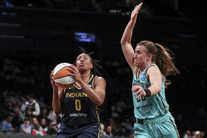 Jun 1, 2022; Brooklyn, New York, USA; Indiana Fever guard Kelsey Mitchell (0) drives past New York Liberty guard Sabrina Ionescu (20) in the first quarter at Barclays Center. Mandatory Credit: Wendell Cruz-USA TODAY Sports