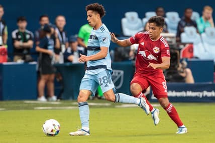 Jul 3, 2022; Kansas City, Kansas, USA; Sporting Kansas City midfielder Cameron Duke (28) drives the ball away from New York Red Bulls midfielder Frankie Amaya (8) during the first half at Children's Mercy Park. Mandatory Credit: William Purnell-USA TODAY Sports