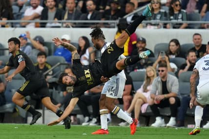 Jul 8, 2022; Los Angeles, California, USA; LAFC midfielder Ryan Hollingshead (24) is upended by LA Galaxy forward Raheem Edwards (44) in the first half at Banc of California Stadium. Mandatory Credit: Kirby Lee-USA TODAY Sports