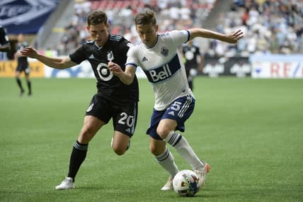 Jul 8, 2022; Vancouver, British Columbia, CAN;  Vancouver Whitecaps FC midfielder Ryan Gauld (25) controls the ball against Minnesota United FC midfielder Will Trapp (20) during the first half at BC Place. Mandatory Credit: Anne-Marie Sorvin-USA TODAY Sports