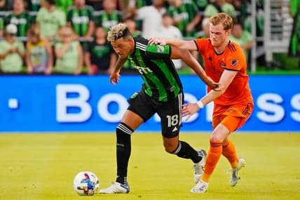 Jul 12, 2022; Austin, Texas, USA; Austin FC defender Julio Cascante (18) dribbles the ball against Houston Dynamo forward Thorleifur Ulfarsson (34) during the first half at Q2 Stadium. Mandatory Credit: Scott Wachter-USA TODAY Sports