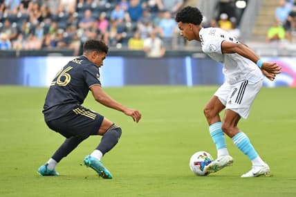 Jul 16, 2022; Chester, Pennsylvania, USA; New England Revolution midfielder Dylan Borrero (27) is defended by Philadelphia Union defender Nathan Harriel (26) during the first half at Subaru Park. Mandatory Credit: Eric Hartline-USA TODAY Sports