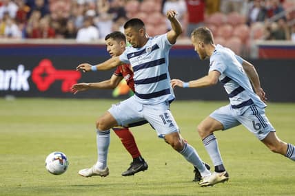 Jul 17, 2022; Sandy, Utah, USA;  Sporting Kansas City midfielder Roger Espinoza (15) and midfielder Oriol Rosell (6) battle Real Salt Lake forward Jefferson Savarino (11) in the first half at Rio Tinto Stadium. Mandatory Credit: Jeffrey Swinger-USA TODAY Sports