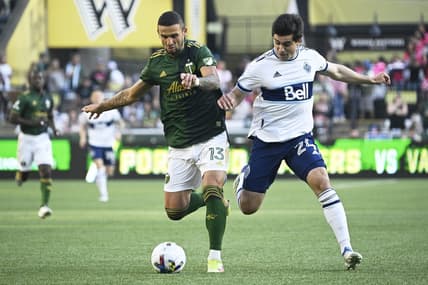 Jul 17, 2022; Portland, Oregon, USA; Portland Timbers defender Dario Zuparic (13) defends Vancouver Whitecaps forward Brian White (24) during the first half at Providence Park. Mandatory Credit: Troy Wayrynen-USA TODAY Sports