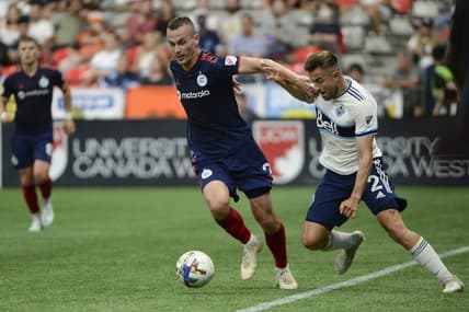 Jul 23, 2022; Vancouver, British Columbia, CAN;  Vancouver Whitecaps FC defender Marcus Godinho (2) challenges Chicago Fire FC defender Boris Sekulic (2) during the first half at BC Place. Mandatory Credit: Anne-Marie Sorvin-USA TODAY Sports