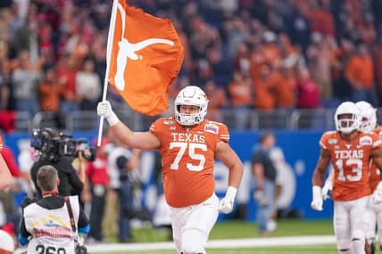 Dec 31, 2019; San Antonio, Texas, USA;  Texas Longhorns offensive lineman Junior Angilau (75) carries a flag onto the field before the game against the Utah Utes at the Alamodome. Mandatory Credit: Daniel Dunn-USA TODAY Sports