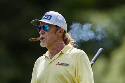 May 29, 2022; Benton Harbor, Michigan, USA; Miguel Angel Jimenez walks off the tee box while smoking a cigar on the thirteenth hole during the final round of the 2022 KitchenAid Senior PGA Championship at Harbor Shores. Mandatory Credit: Raj Mehta-USA TODAY Sports