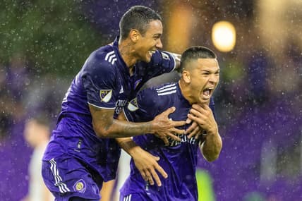 Jul 27, 2022; Orlando, Florida, US;   Orlando City midfielder Cesar Araujo (5) is congratulated by defender Antonio Carlos (25) after scoring his second goal of the match against the New York Red Bulls in the second half during the US Open Cup semifinals at Exploria Stadium. Mandatory Credit: Nathan Ray Seebeck-USA TODAY Sports