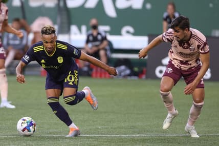 Aug 3, 2022; Portland, Oregon, USA;  Nashville SC midfielder Hany Mukhtar (10) dribbles around Portland Timbers defender Jose van Rankin (2) during the first half at Providence Park. Mandatory Credit: Jaime Valdez-USA TODAY Sports
