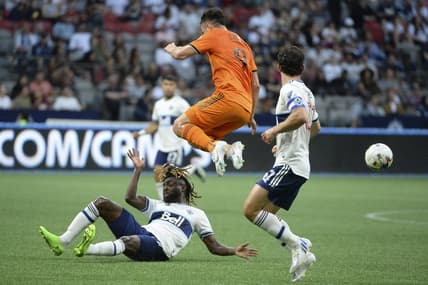 Aug 5, 2022; Vancouver, British Columbia, CAN;  Houston Dynamo FC forward Sebastian Ferreira (9) jumps over Vancouver Whitecaps FC midfielder Leonard Owusu (17) during the first half at BC Place. Mandatory Credit: Anne-Marie Sorvin-USA TODAY Sports