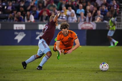 Aug 20, 2022; Commerce City, Colorado, USA; Houston Dynamo FC defender Adam Lundqvist (3) falls in front of Colorado Rapids forward Michael Barrios (12) in the first half at Dick's Sporting Goods Park. Mandatory Credit: Ron Chenoy-USA TODAY Sports