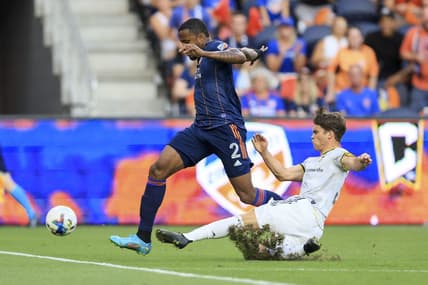 Aug 27, 2022; Cincinnati, Ohio, USA;  Columbus Crew SC defender Josh Williams (right) attempts to tackle against FC Cincinnati defender Alvas Powell (2) in the first half at TQL Stadium. Mandatory Credit: Aaron Doster-USA TODAY Sports